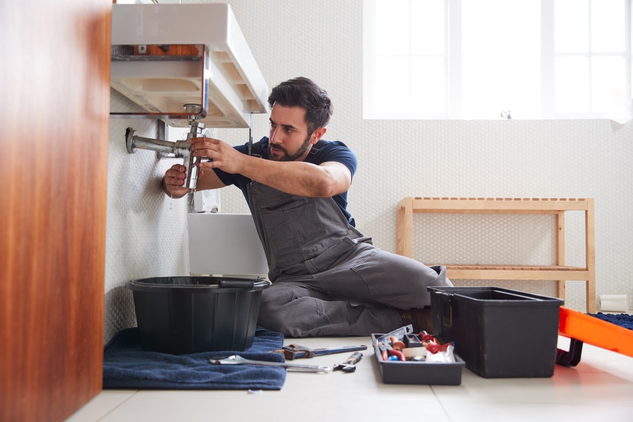 fontanero con barba arregla lavabo